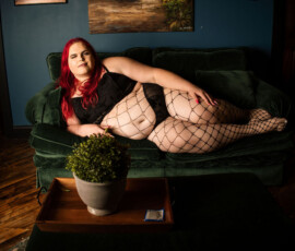 TS Escort TS Audacia posing in a luxury room on a velvet sofa
